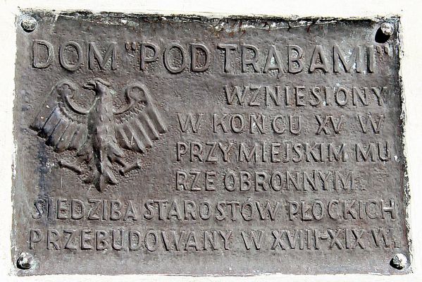Tablica informacyjna, umieszczona na ścianie Domu Pod Trąbami.
