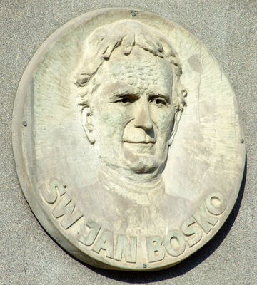 św. Jan Bosko
płaskorzeźba znajdująca się nad bocznym 
wejściem do dolnego kościoła 
Kościół p.w. św. Stanisława Kostki
