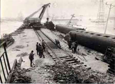 podnoszenie wykolejonego składu pociągu na zjeździe z mostu 
Radziwie 1982r.
Słowa kluczowe: wykolejony pociąg powódź Płock Radziwie 1982r.